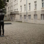 Innenhof des Bendlerblocks, link ist die Gedenkstatue an Graf Stauffenberg von hinten aus zu sehen, rechts ein Gedenkkranz an der Innenhofmauer